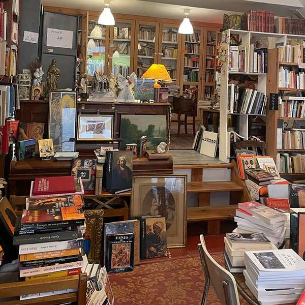 Intérieur de la librairie La Maison Livre à Montolieu, avec rayonnages et livres.